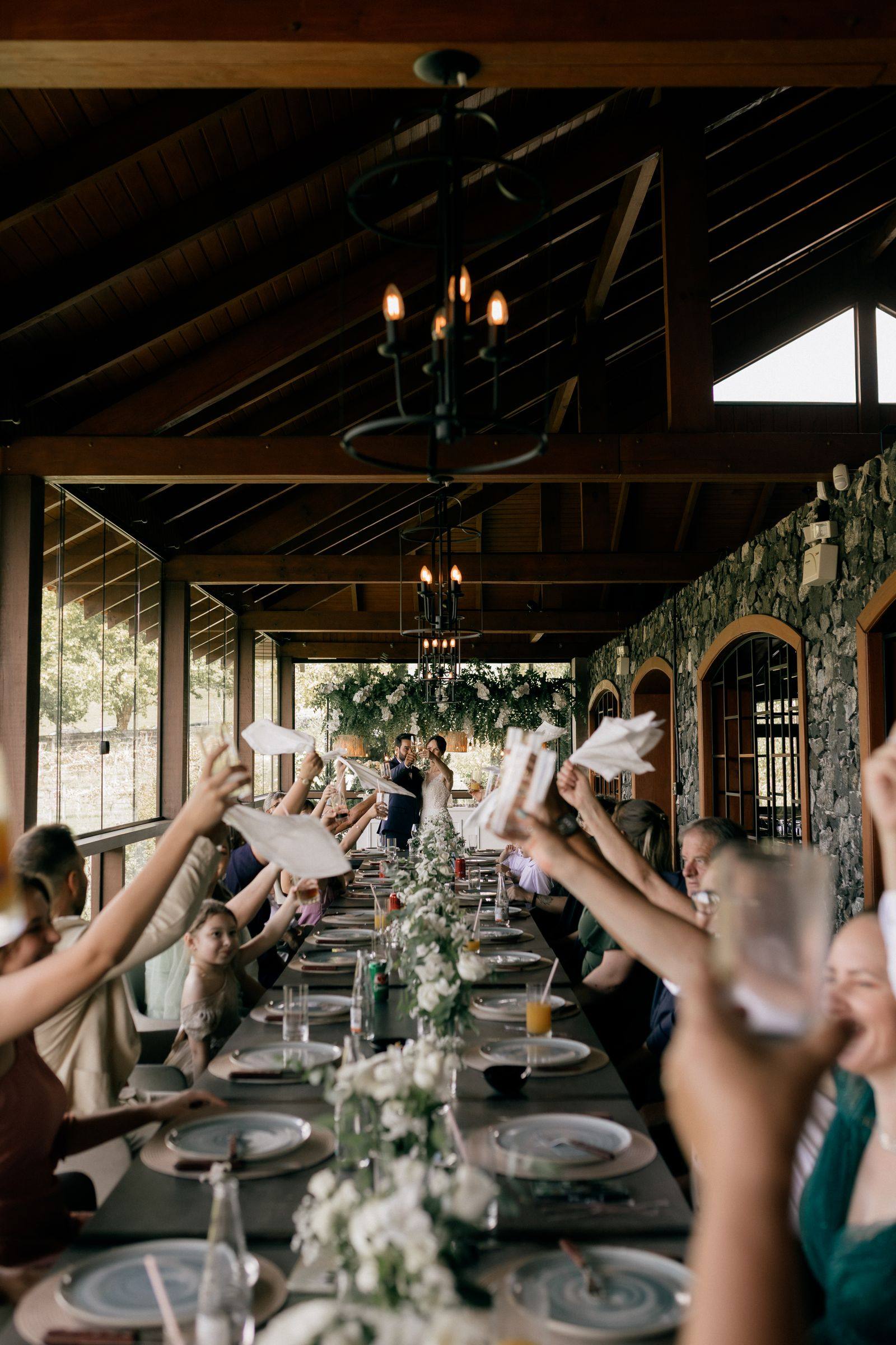 Guests raising glasses at a candlelit outdoor celebration