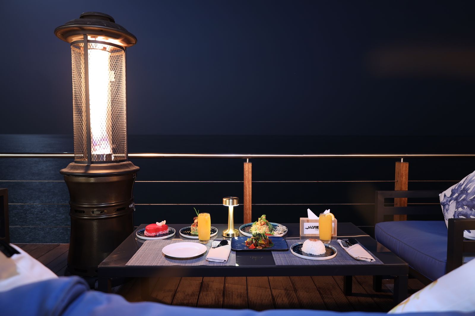 A table set for dinner above the sea at night