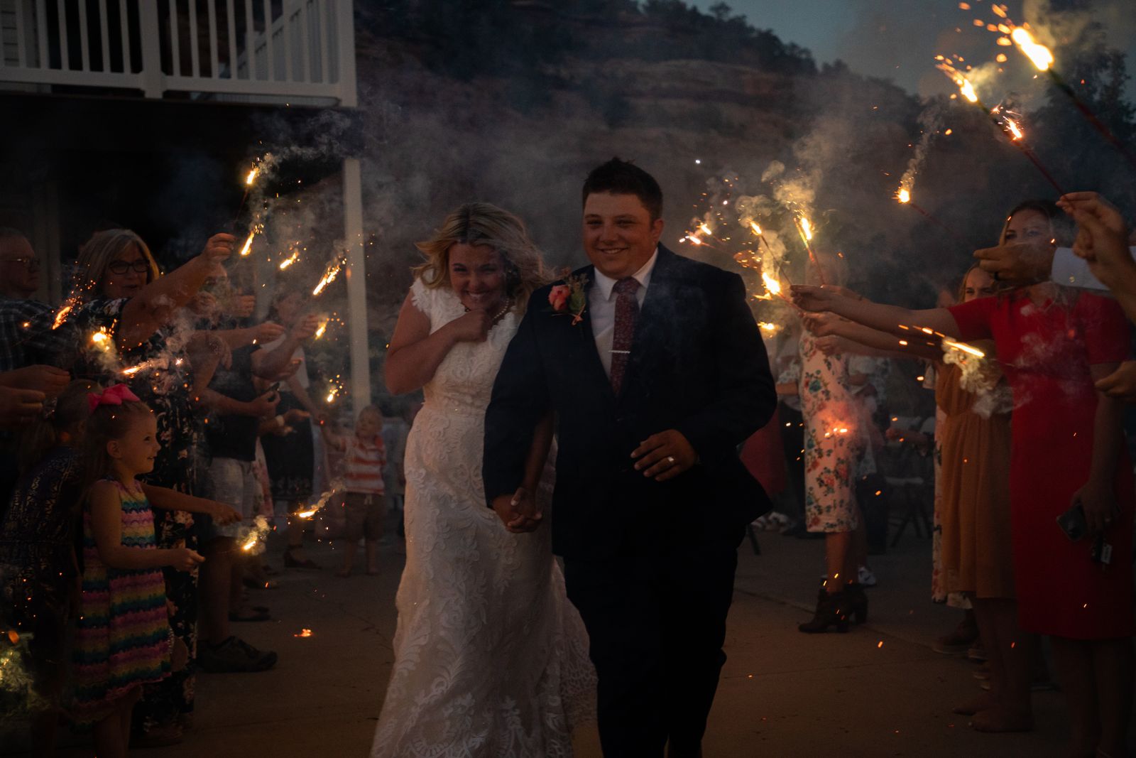 Newlyweds walking through a corridor of sparklers