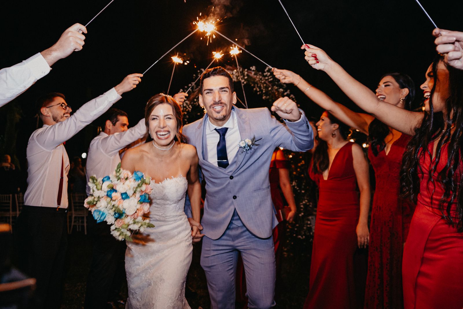 A couple walking through sparklers at night